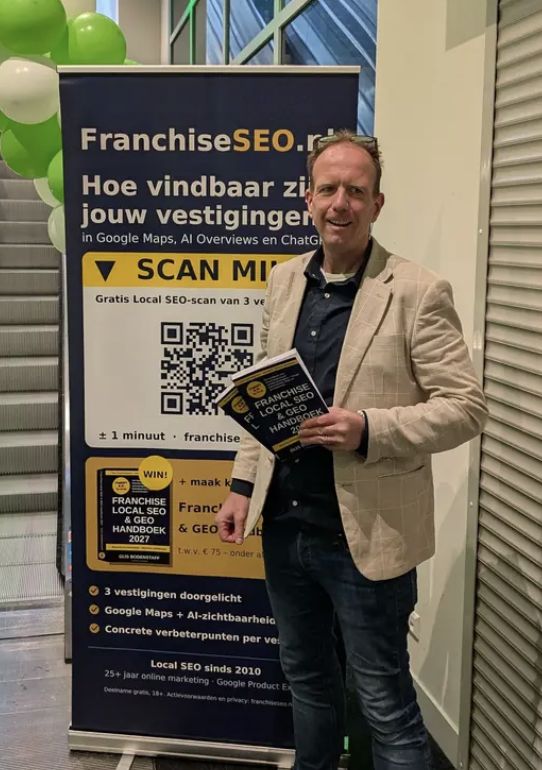 Auteur Gijs Bodenstaff met de tweede druk van het Franchise Local SEO & GEO Handboek 2027 bij de rolbanner op De Nationale Franchise Beurs in Gorinchem