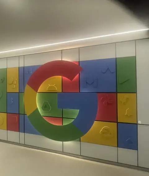 Wand met het Google-logo in het kantoor van Google in Amsterdam, de auteur van deze boeken als spreker