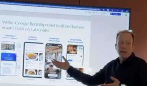 Gijs Bodenstaff wijst naar nieuwe functies van Google Bedrijfsprofiel op een slide, de auteur van deze boeken als spreker